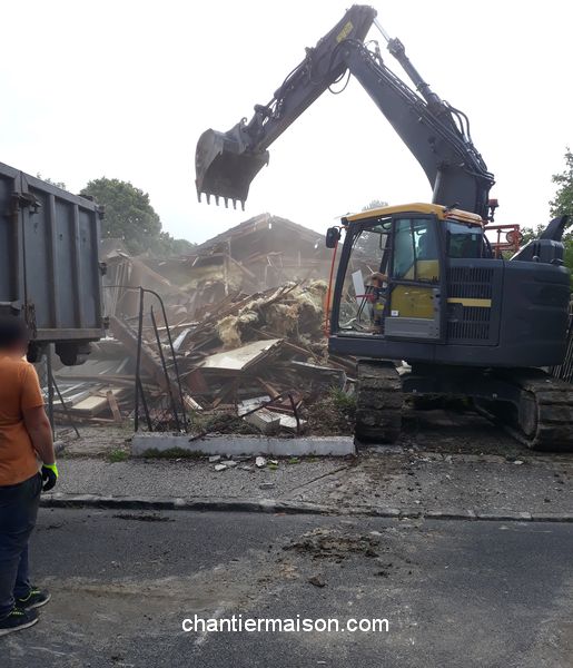 démolition d'une maison avec une pelleteuse